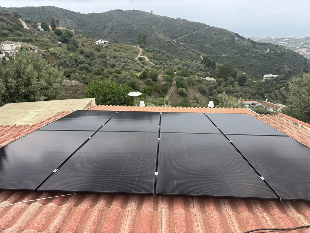 Paneles solares negros en tejado de teja con vistas a la Axarquía